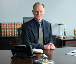 John Bradshaw sits at his desk