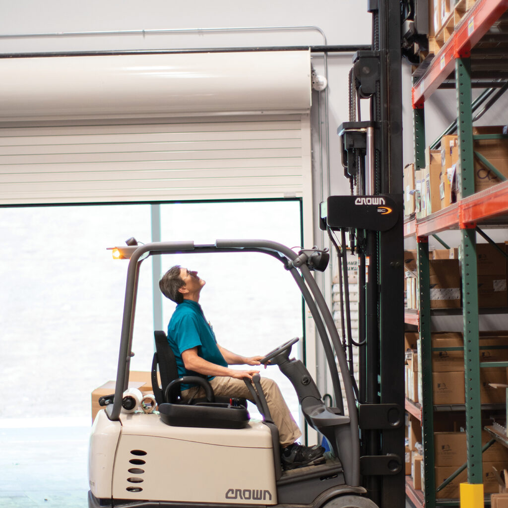 a worker on a forklift in the warehouse